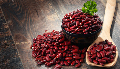 Composition with bowl of kidney bean on wooden table - obrazy, fototapety, plakaty