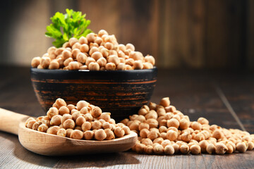 Composition with bowl of chickpeas on wooden table