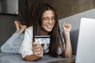 Woman purchasing online while sitting on a couch