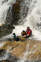 Asian family refreshing in Lasir Waterfall in Lake Kenyir, Terengganu Malaysia.