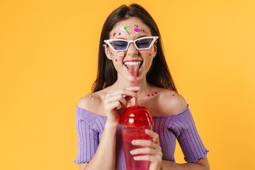 Image of joyful woman drinking cocktail and showing her tongue