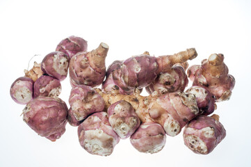 several sweet potatoes photographed on a white background in the studio
