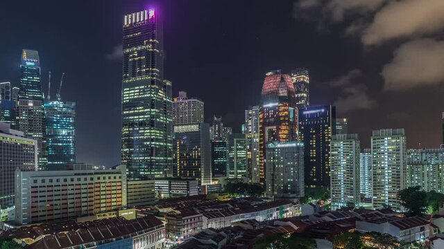 Aerial view of Chinatown with red roofs and Central Business District illuminated skyscrapers timelapse, Singapore. Contrast between old and modern buildings. Traffic on streets