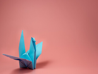 Paper origami dove of peace on a pink background.