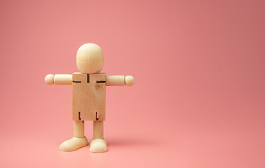 A Wooden doll on pink background.