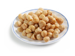 peeled macadamia nuts on a white saucer with a blue border, isolated on a white background