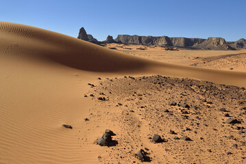 Fototapeta na wymiar TADRART NATIONAL PARK IN THE SAHARA DESERT IN ALGERIA. SAND DUNES AND ROCK FORMATIONS. SAFARI AND ADVENTURE IN ALGERIA. TOURISM IN ALGERIA