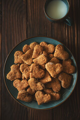 Top view on homemade wholegrain cookies with oatmeal, raisin, nuts, seeds and milk on brown rustic wooden background. Healthy eating concept.  Copy space