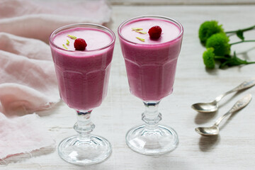 Berry-fruit mousse decorated with raspberries on a light background.