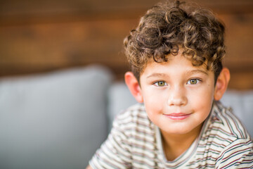 Handsome young boy with curly hair smiling.