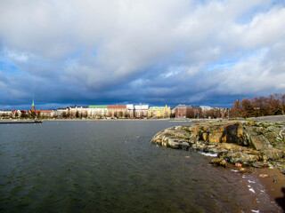 Fototapeta na wymiar Panorama of Helsinki seen from an island with partly cloudy sky on the background.