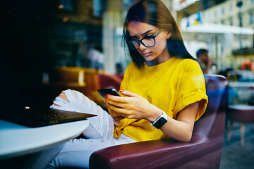 Pondering attractive freelancer in cool spectacles checking important notification from banking...