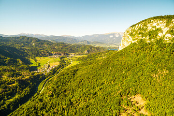 Aerial wiew to the green nature nd village in the mountains of Slovenia with blue sky. Travel in...