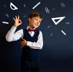 Back to school. Education. Happy schoolboy with a drawn school supplies: ruler, protractor, paper...