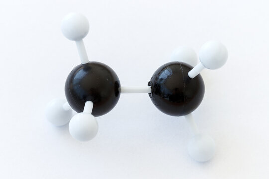 Plastic ball-and-stick model of an ethane molecule (C2H6) on a white background.