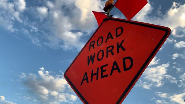 Road Work Ahead Sign against a Blue Sky