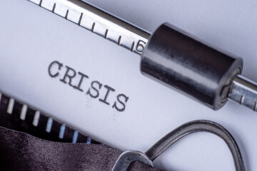 Crisis typed on white paper with retro typewriter