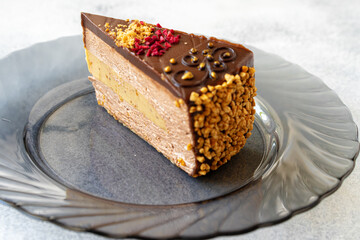 Piece of chocolate cheesecake with nuts close up