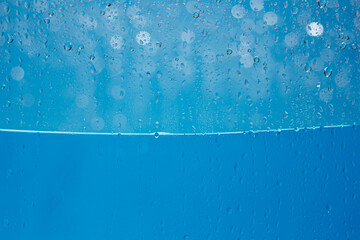 Blue water drops background. Blue water drops on a boat glass background.