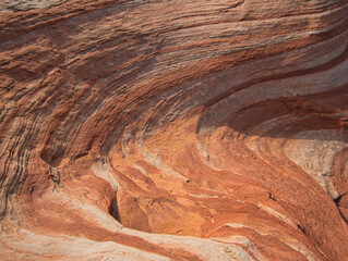 Wellenförmige Felsen mit Linien und Spuren im Sand