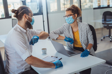 
Business people greeting during COVID-19 pandemic, elbow bump. Colleagues in the office practicing alternative greeting to avoid handshakes during COVID-19 pandemic
