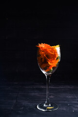 flowers in a wine glass on black background