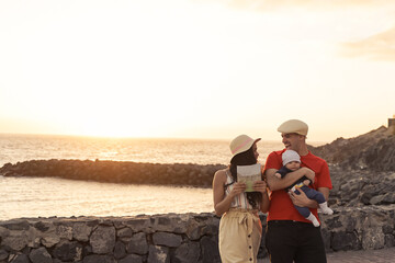 Happy young family walking near the beach, day with a perfect sunset.  Sunset, travel and holiday...