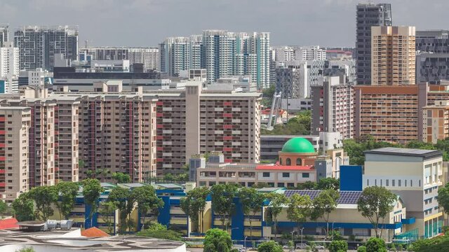 Singapore skyline with Victoria street and shoping mall aerial timelapse. Green trees on the road with traffic. Clouds on a blue sky