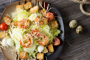 Caesar salad with prawns on a plate in a cafe