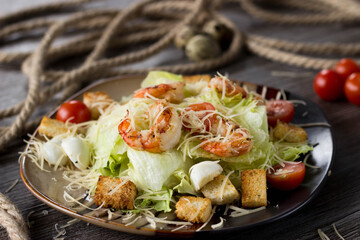 Caesar salad with prawns on a plate in a cafe