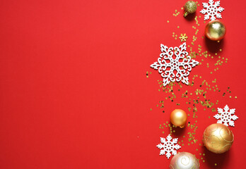 Beautiful Christmas decoration with gifts and balls on a red background. View from above. New Year's layout.