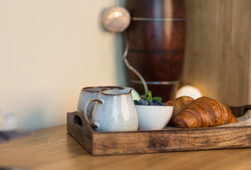 romantic breakfast with fresh croissants coffee,milk and berries on wooden table