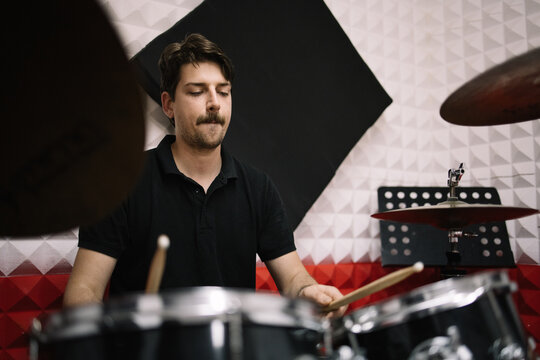 Musician Man Playing Drums And Cymbals With Drumsticks. Repetition Of Rock Music Drummer In Soundproof Studio.