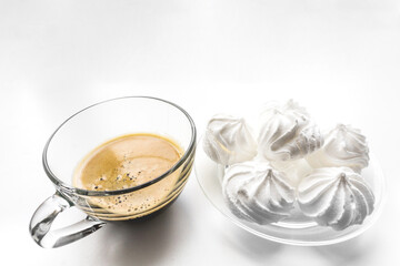 Latte and cappuccino with copy space. Invitation on coffee with sweet. White zephyr or french vanilla meringue cookies and coffee in glass mug for bakeries and coffee shop on white background. 