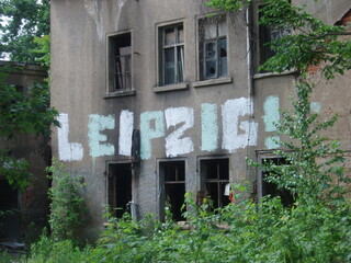 Fototapeta na wymiar An abandoned house in Leipzig, Germany bears the enthusiastic graffiti, 