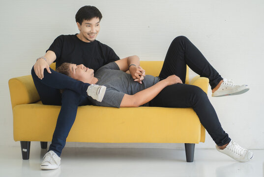 A gay couple having fun on Shofa in the room.