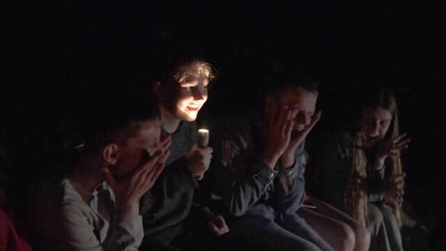 Teenager Telling Scary Story Using Flashlight On Face.