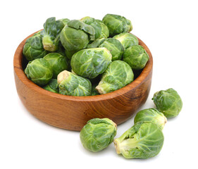 freshly brussel sprouts  in wooden bowl on a white background