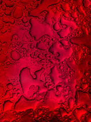 Gotas de agua sobre una superficie de metal de color rojo