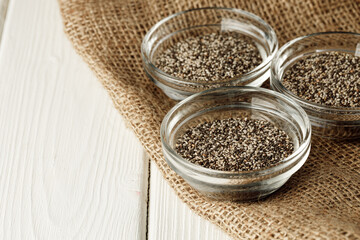 Glass bowl with chia seeds on wooden table