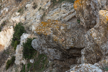Texture of a sand rock in close-up for the entire frame. Yellow loose rock. Stone natural red background. Steep sea shores.