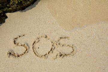 Inscription SOS in the sand