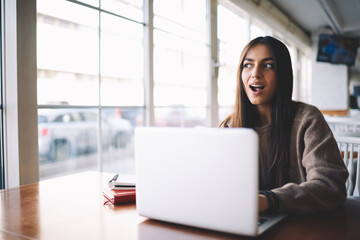 Emotional young freelancer feeling surprised received message with job offer checking email box via...