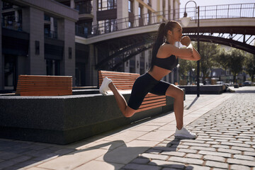 Young beauty Asian woman workout doing squats outdoor rooftop.Fitness practice training health care...
