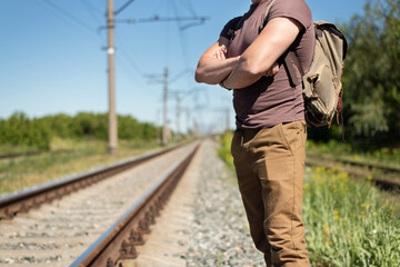 Tourist is waiting for a train on the railroad.