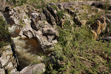 The rapids. View of the river flowing along the rocky cliffs in the mountain forest. 