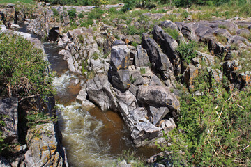The rapids. View of the river flowing along the rocky cliffs in the mountain forest. 