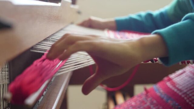 making traditional tapestry on a wooden weaving loom slow motion
