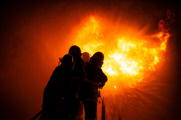 Operation emergency firefighter spraying high pressure water to fire, Professional team fireman...