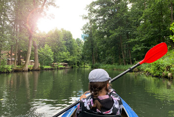 Fototapeta na wymiar Ein Mädchen paddelt mit einem Kanu im Spreewald in Burg am 12.07.2020.
